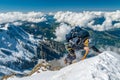 Extreme alpinist in high altitude on Aiguille de Bionnassay mountain summit, Mont Blanc massif, Alps, France