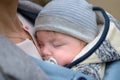 Extreme close up of a baby sleeping in a baby carrier, in an extraordinary closeness to his mother Royalty Free Stock Photo