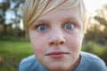 Extreme close up of blonde caucasian boy with big blue eyes and freckles Royalty Free Stock Photo