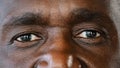 Extreme close up body part human male wrinkled face african american senior elderly adult man with dark iris eyesight