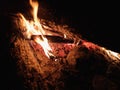 Extreme close up of fire sparks moving on dark night sky as black background coming from brightly burning warm outdoors Royalty Free Stock Photo