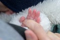Extreme close up of the hand of little baby holding mothers hand with his little fingers Royalty Free Stock Photo