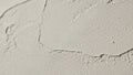 Macro shot of textured light gray plaster wall with subtle sparkle surface background Royalty Free Stock Photo