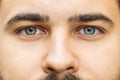 Extreme close-up macro portrait of young face, bearded man's eyes looking at camera, smiling Royalty Free Stock Photo