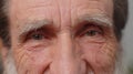 Extreme close-up macro portrait of wrinkled face, old senior beautiful man's eyes looking at camera Royalty Free Stock Photo