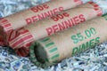 Extreme close up of rolls of pennies and dimes bedded on shreds of unfit US currency.