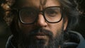 Extreme close up serious calm Arabian male face in eyeglasses looking at camera portrait headshot Muslim guy bearded