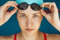 Extreme close-up shot of a Caucasian girl head with a swimming cap and hands putting swimming goggles, preparing for Royalty Free Stock Photo