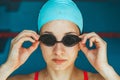 Extreme close-up shot of a Caucasian girl head with a swimming cap and hands putting swimming goggles, preparing for Royalty Free Stock Photo