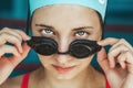 Extreme close-up shot of a Caucasian girl head with a swimming cap and hands putting swimming goggles, preparing for Royalty Free Stock Photo