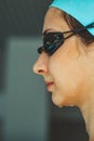 Extreme close-up shot of a Caucasian girl head with a swimming cap and hands putting swimming goggles, preparing for Royalty Free Stock Photo