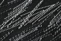 Extreme close up, top down view of macro polypropylene sinusoidal fibers for concrete reinforcement on black stone background