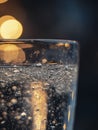 An extreme close-up of a transparent glass filled with drinking water, illuminated by a bright light source Royalty Free Stock Photo
