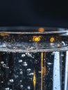 An extreme close-up of a transparent glass filled with drinking water, illuminated by a bright light source Royalty Free Stock Photo