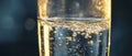 An extreme close-up of a transparent glass filled with drinking water, illuminated by a bright light source Royalty Free Stock Photo