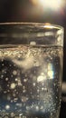 An extreme close-up of a transparent glass filled with drinking water, illuminated by a bright light source Royalty Free Stock Photo