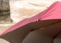 Extreme Close up of UV umbrella in the summer sun. Red color beach umbrella blocking the sunlight. Sunbath tanning shade shadow