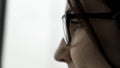 Extreme close up for young female face portrait in profile in black glasses on fuzzy, white background. Beautiful woman Royalty Free Stock Photo