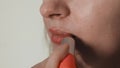 Young Woman Paints Lips with Red Lipstick. Doing Makeup Beauty Extreme Close up