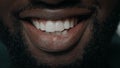 Extreme closeup bearded african man smiling with white teeth at camera.