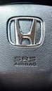 Close-up shot of a Honda Logo with SRS AirBag on a car steering wheel..