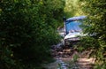 Extreme driving, challenge and 4x4 vehicles concept. Offroad race in forest. SUV or offroad car rides in deep puddle Royalty Free Stock Photo