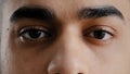 Extreme facial close up young hispanic male eyes arab man with brown eyeballs blinking looking at camera demonstrate Royalty Free Stock Photo