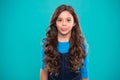 Extreme hair volume. Kid girl long healthy shiny hair. Kid happy cute face with adorable curly hairstyle stand over blue Royalty Free Stock Photo