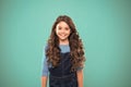 Extreme hair volume. Kid girl long healthy shiny hair. Kid happy cute face with adorable curly hairstyle stand over blue Royalty Free Stock Photo