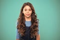 Extreme hair volume. Kid girl long healthy shiny hair. Kid happy cute face with adorable curly hairstyle stand over blue Royalty Free Stock Photo