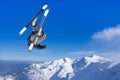Extreme Jumping skier at jump above mountains