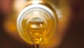 Extreme macro of olive oil poured from an original bottle. Stock footage. Close-up of oil pouring out of the bottle Royalty Free Stock Photo