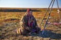 The extreme north Yamal life of Nenets people reindeer herder\'s assistant woman sitting on the ground waiting