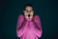 Close up portrait of young crazy scared and shocked woman isolated on dark background