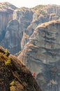 Extreme rock climber climbing on peak of one of the Meteora rock formations cliffs