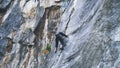 Extreme rock climber climbs difficult route in the mountains