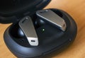 Extreme shallow depth of field, Macro shot of Futuristic design small wireless headphones or earphone lie on a green wooden