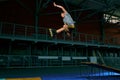 Rollerblader jump high from big air ramp performing trick. Indoors skate park equipment. Royalty Free Stock Photo