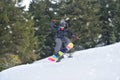 Extreme Sports Action: Snowboarder Soaring Through the Air on a Hillside Jump Royalty Free Stock Photo