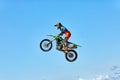 Extreme sports, motorcycle jumping. Motorcyclist makes an extreme jump against the sky.