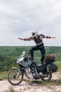 Extreme stunt on a bike. Like surfing. Motorcycle driver wearing a turtle jacket, body armor and a helmet. Stands on top. Vertical Royalty Free Stock Photo