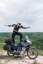 Extreme stunt on a bike. Like surfing. Motorcycle driver wearing a turtle jacket, body armor and a helmet. Stands on top. Vertical Royalty Free Stock Photo