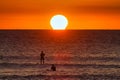 Extreme telephoto scene of stand up paddle boarder at sunset. Royalty Free Stock Photo