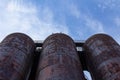 Extreme upward view of three large metal tanks against a blue sky Royalty Free Stock Photo