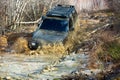 Extreme weekends. A car during a tough off-road competition diving in a muddy pool. Driver competing. Royalty Free Stock Photo