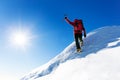 Extreme winter sports: climber at the top of a snowy peak in the