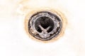 Extremely dirty bath drain mesh, hole covered with limescale or lime scale and rust close up, cleaning calcified and rusty