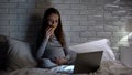 Extremely emotional pregnant woman crying, eating donuts, watching melodrama Royalty Free Stock Photo