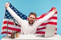 Extremely happy businessman raising American flag and yelling crazy for joy in office workplace, celebrating labor day Royalty Free Stock Photo