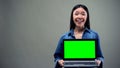 Extremely happy woman holding laptop with green screen, big winnings online